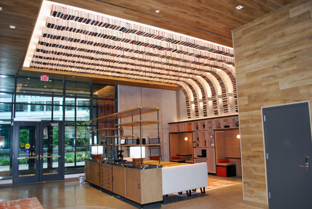 modern lobby with integrated book-themed overhead lighting fixture